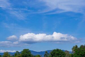 Blue sky with white clouds and mountain background photo