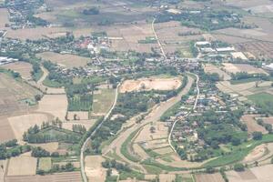 aéreo ver de agrícola campo, río y nubes visto mediante avión ventana foto