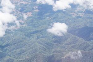 Aerial view of agricultural fields, river, mountains, and land have seen through the airplane window photo