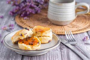 Close-up of traditional British scones and cookies on a plate with a teacup and flower blurred background. Space for text photo