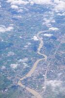 Aerial view of lands and clouds seen through airplane window photo