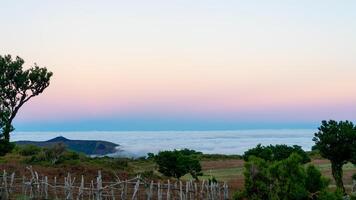 Morning on Madeira with a serene view of the sea blanketed by clouds under a pastel sky photo