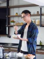 Young man use whisk and bowl for mixing in a bowl photo