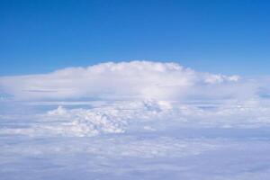 Aerial view of clouds and sky seen through the airplane window photo