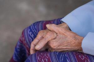 de cerca de manos mayor mujer unido juntos. atención en manos arrugado piel. espacio para texto. concepto de Envejecido personas y cuidado de la salud foto