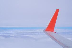 Aerial view of sky seen through the airplane window. Bright blue sky and white clouds with skyline background. Space for text photo