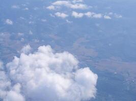 Aerial view of lands and clouds seen through airplane window photo