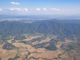 Aerial view of lands and clouds seen through the airplane window photo