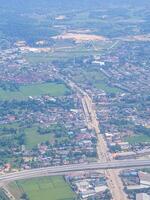 Aerial view of agricultural field, river, road, and townscape is seen through the airplane window photo