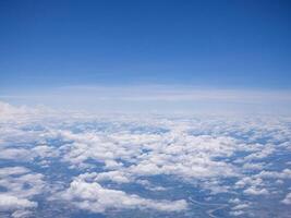 Aerial view of clouds and sky seen through the airplane window photo