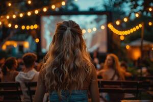 people watching outdoor cinema, big screen show. view from behind. photo