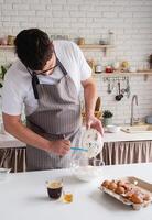 hombre vistiendo delantal Cocinando Tiramisu a cocina foto