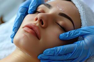 Close up portrait of a young woman patient receiving a laser treatment in a spa salon. photo