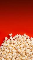 Popcorn scattered on a red background. A classic movie theater snack. View from above. photo