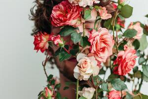 Beautiful young man in roses flowers on white background. photo