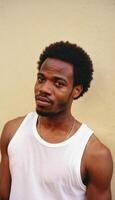 photo of black person man with white tank top in neighborhood ,