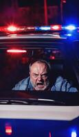 photo of portrait close up view of criminal suspect in crime scene standing in front of police car at night and red blue light,