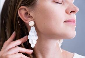 Cheerful woman with white seashell earrings, beautiful face closeup photo