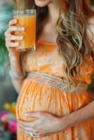 happy pregnant woman drinking green vegetable juice or smoothie at home. photo