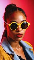 photo of beautiful african woman with style sunglasses standing against red and yellow background,