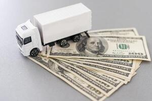 White toy truck lie on dollars, space for text. photo
