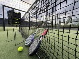 Background of padel racket and ball on artificial grass floor in outdoor court. Top view. photo