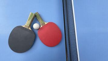 Table tennis rackets and ball on tennis table photo