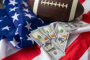 dinero y rugby pelota en americano bandera fondo, de cerca. concepto de Deportes apuesta foto