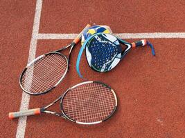 The broken rackets for playing tennis are hanging on the wall of a sports tennis club. photo