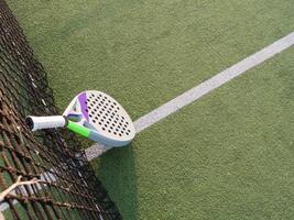 antecedentes de padel raqueta y pelota en artificial césped piso en al aire libre corte. parte superior vista. foto