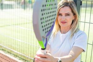 un hembra paleta tenis jugador después jugando un fósforo. foto