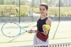 Girl with a racket on the tennis court. photo