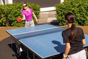 mesa tenis. madre y hija jugar silbido apestar juego. foto