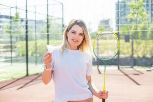 Beauty sport. Pretty young woman in fitness clothes. Slim body. Look at camera. Badminton exercise. Power wellness. Workout lifestyle. Training position. photo