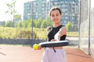 padel tenis jugador con raqueta y pelota en manos. niña atleta con paleta raqueta en Corte al aire libre. deporte concepto. descargar un alto calidad foto para el diseño de un Deportes aplicación o web sitio.