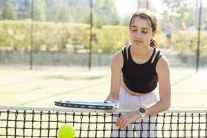 Girl with a racket on the tennis court. photo