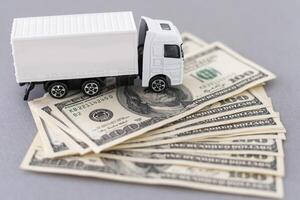 White toy truck lie on dollars, space for text. photo