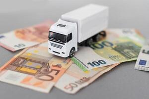 White toy truck lie on dollars, space for text. photo