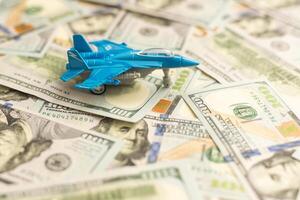 Background of one hundred dollar bills with model fighter airplane photo