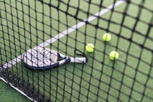 paleta tenis raqueta, pelota y red en el césped foto