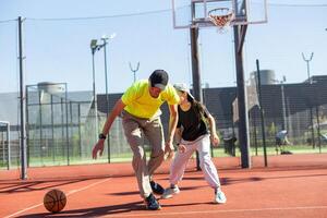 A father and daughter playing basketball in the park photo