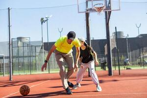 A father and daughter playing basketball in the park photo