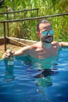 young man enjoying vacation at the beach and pool photo