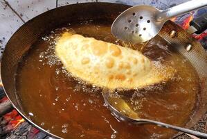 fogazza being fried in a pan with hot oil photo