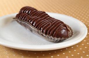 Chocolate eclair on plate on the table photo