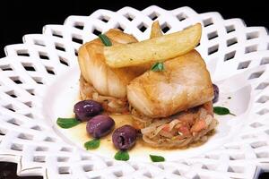 baked cod with onions, french fries and olives photo