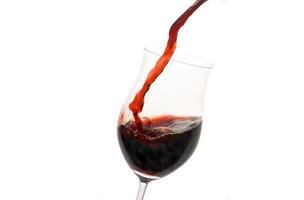 rojo vino siendo servido en un vaso en un blanco antecedentes foto