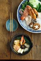 Nabemono, classic Japanese cuisine with shrimp, tofu and mushrooms photo