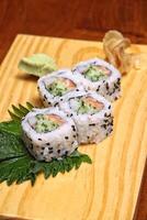 Traditional Uramaki, Japanese delicacy with nori, sesame, rice vinegar, kani kama and Japanese cucumber photo