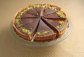 Chocolate pie with sliced pistachios in glass dish photo